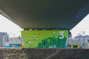 Vibrant mural with soccer players under a highway bridge, showcasing street art in an urban environment. jigsaw puzzle