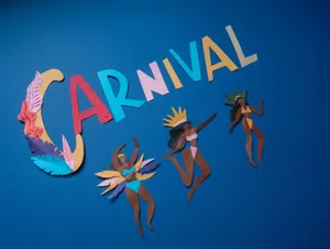 Vibrant paper cutouts depict Carnaval dancers against a striking blue backdrop. jigsaw puzzle