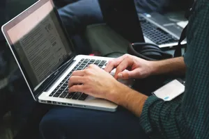 A programmer typing on a laptop in an indoor setting, showcasing technology in use. jigsaw puzzle