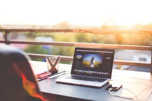 A modern workspace on a balcony with a laptop and smartphone during sunset, capturing a creative work environment. jigsaw puzzle