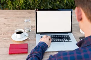 Adult working on laptop outdoors with coffee and notepad, promoting remote work flexibility. jigsaw puzzle