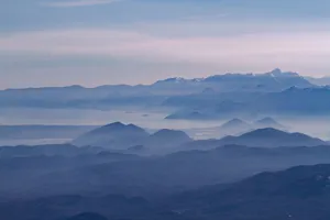 A serene view of Montenegro's mountain landscape with misty layers and distant peaks at dawn. jigsaw puzzle