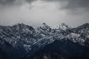 Stunning image of snow-covered mountains under a cloudy sky in Sankri, India. jigsaw puzzle