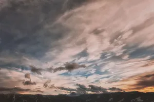 A breathtaking view of dramatic clouds and colorful sky at sunset with mountain silhouettes. jigsaw puzzle