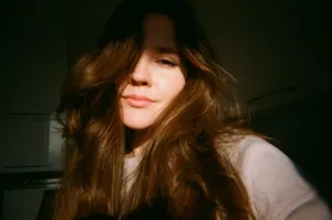 Analog-style portrait of a young woman indoors with warm lighting. jigsaw puzzle