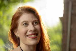 Close-up of a smiling woman with red hair highlighted by sunlight in Buenos Aires. jigsaw puzzle
