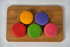 Vibrant macarons in a rainbow of colors displayed on a wooden board. jigsaw puzzle