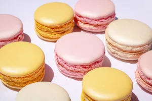 Vibrant assortment of colorful French macarons in shades of pastel pink, yellow, and cream. jigsaw puzzle