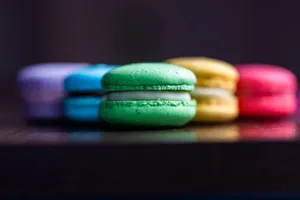 Vibrant macarons in green, yellow, red, and purple perfectly lined for a tasteful visual treat. jigsaw puzzle