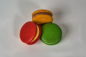 A vibrant trio of red, green, and yellow macarons displayed on a white surface. jigsaw puzzle