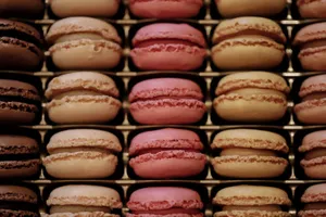 Close-up view of assorted colorful macarons perfectly arranged in rows on a tray. jigsaw puzzle