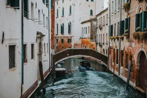 Charming Venetian canal with arched bridge and boats, showcasing classic Italian architecture. jigsaw puzzle