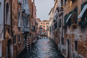 Rippled water channel between aged building exteriors with rough brick walls and columns in Venice Italy jigsaw puzzle