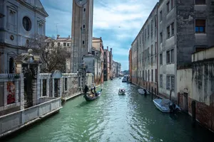 Picturesque view of a canal in Venice, Italy, featuring a gondola and historic architecture under a clear sky. jigsaw puzzle