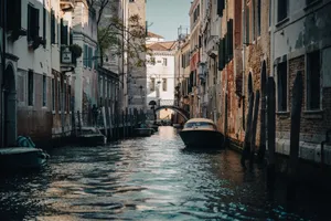 Serene daytime view of a Venetian canal flanked by historic buildings and moored boats, in Venice, Italy. jigsaw puzzle
