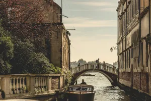Captivating view of a Venetian canal with a bridge and boat, showcasing historic architecture. jigsaw puzzle