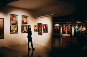 A woman admiring colorful paintings in a contemporary indoor art exhibition. jigsaw puzzle