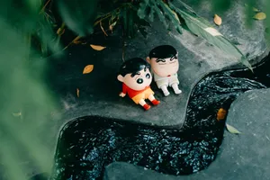 Adorable cartoon dolls sitting near a flowing stream surrounded by lush greenery. jigsaw puzzle