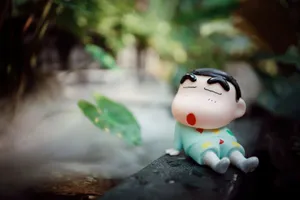 A cute toy figurine sleeping in a lush, natural outdoor setting. jigsaw puzzle