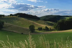 Breathtaking view of green hills and fields under a vibrant sky. jigsaw puzzle
