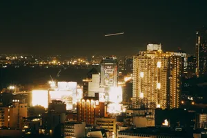A stunning nighttime cityscape featuring illuminated skyscrapers and vibrant urban lights. jigsaw puzzle