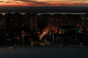 Elevated view of a city skyline during dusk with building lights glowing and a vivid sunset. jigsaw puzzle