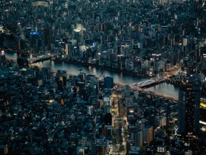 Stunning aerial shot of Tokyo cityscape at night featuring illuminated buildings and river. jigsaw puzzle