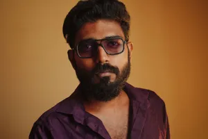 A close-up portrait of an adult man with a beard wearing sunglasses and a purple shirt. jigsaw puzzle