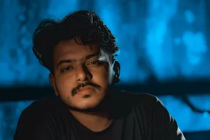 Close-up of a young man with facial hair in a dark, moody setting. jigsaw puzzle