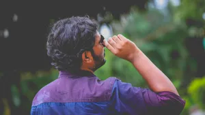 Man in purple shirt adjusting sunglasses while looking up outdoors. jigsaw puzzle