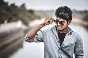 Portrait of a confident young man wearing sunglasses and gray long sleeves shirt outdoors. jigsaw puzzle