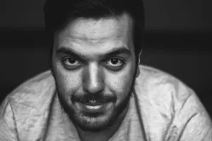 Close-up black and white portrait of a young man with facial hair and intense gaze. jigsaw puzzle