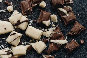 Close-up of assorted milk and white chocolate pieces with artistic drizzle. jigsaw puzzle