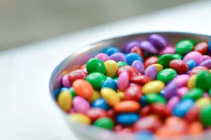 Vibrant close-up of assorted candy-coated chocolates in a silver bowl. jigsaw puzzle
