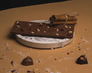 Delicious chocolate bar with nuts and berries on a marble plate, garnished with cinnamon sticks. jigsaw puzzle