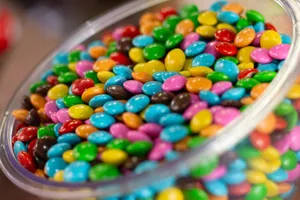A glass bowl filled with colorful candy-coated chocolates, perfect for a festive party setting. jigsaw puzzle