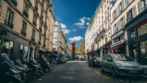 Picturesque Paris street scene featuring classic architecture, parked motorbikes, and cars. jigsaw puzzle