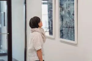 A woman in a gallery intently observes abstract paintings, highlighting her engagement with modern art. jigsaw puzzle