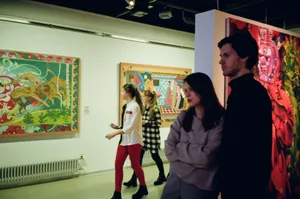 Visitors engaged with vibrant art pieces in a St. Petersburg gallery, showcasing modern creativity. jigsaw puzzle