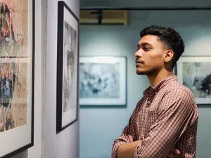 Young man admiring artwork in a contemporary art gallery with framed pictures on the wall. jigsaw puzzle