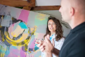 Two adults discuss vibrant abstract painting in a studio. Creative interaction captured. jigsaw puzzle