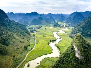Stunning aerial photo of a green valley with winding river and hills under a cloudy sky. jigsaw puzzle
