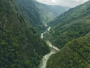 Scenic aerial view of a lush green valley with a winding river in Ghandruk, Nepal, highlighting natural beauty and tranquility. jigsaw puzzle