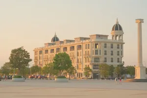 A classic building with domes in a sunny plaza with people strolling. jigsaw puzzle