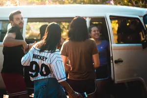 Group of young adults enjoying a sunny day, gathering near a van. jigsaw puzzle
