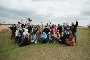 A diverse group of photographers posing together in a natural setting with cameras. jigsaw puzzle