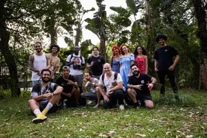 A diverse group posing happily together in a lush, outdoor setting. jigsaw puzzle