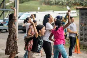 A joyful group of diverse people celebrating with raised arms in an outdoor setting. jigsaw puzzle