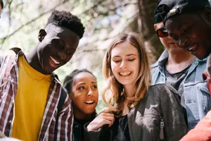 A group of diverse young adults enjoying a moment together outdoors, smiling and happy. jigsaw puzzle