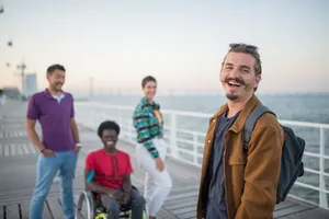 Four friends smiling together on a scenic pier in Portugal, enjoying a peaceful summer day. jigsaw puzzle